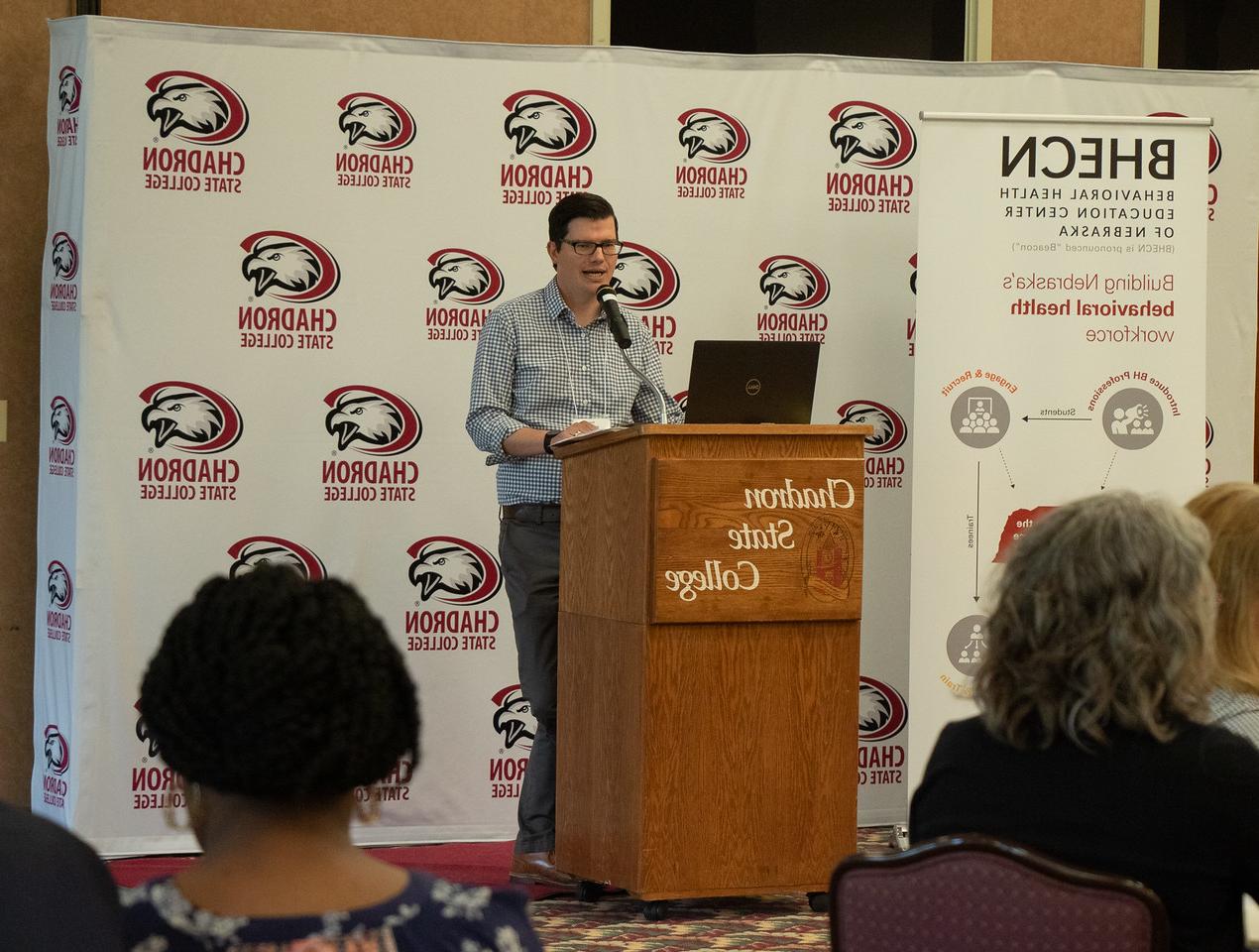 Man at a podium speaking to an audience